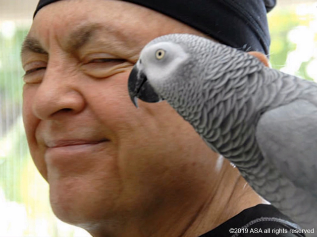 Photo of Adi Da Samraj smiling with a gray bird on his shoulder