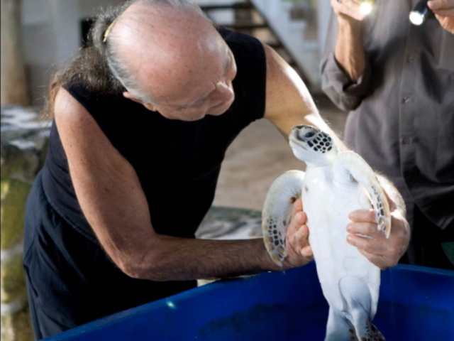 Photo of Adi Da Samraj smiling and holding a turtle